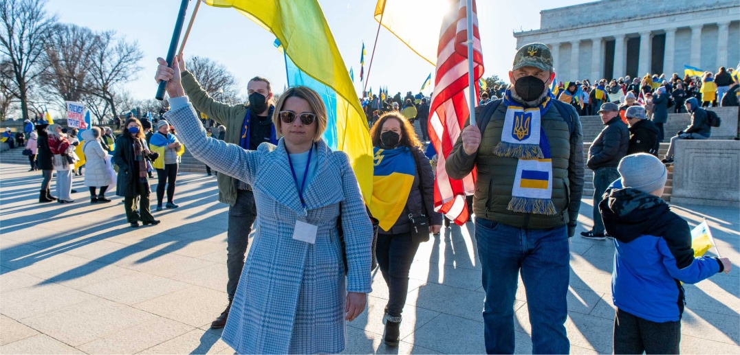 A man and a woman during the rally in support of Ukraine carried Ukrainian and American flags.