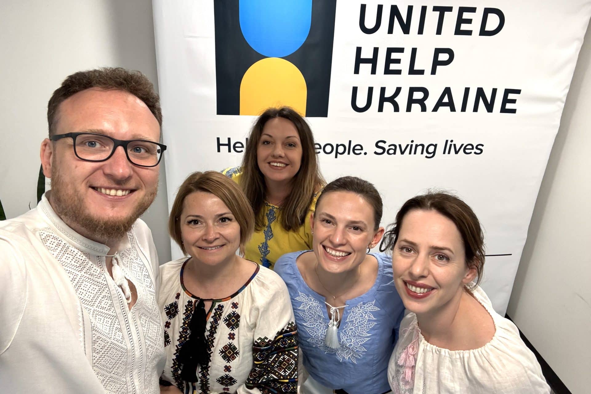 Four women and one man wearing Ukrainian national outfits, vyshyvanka, while celebrating the Vyshyvanka Day 2025 in Civilians HELP's office.
